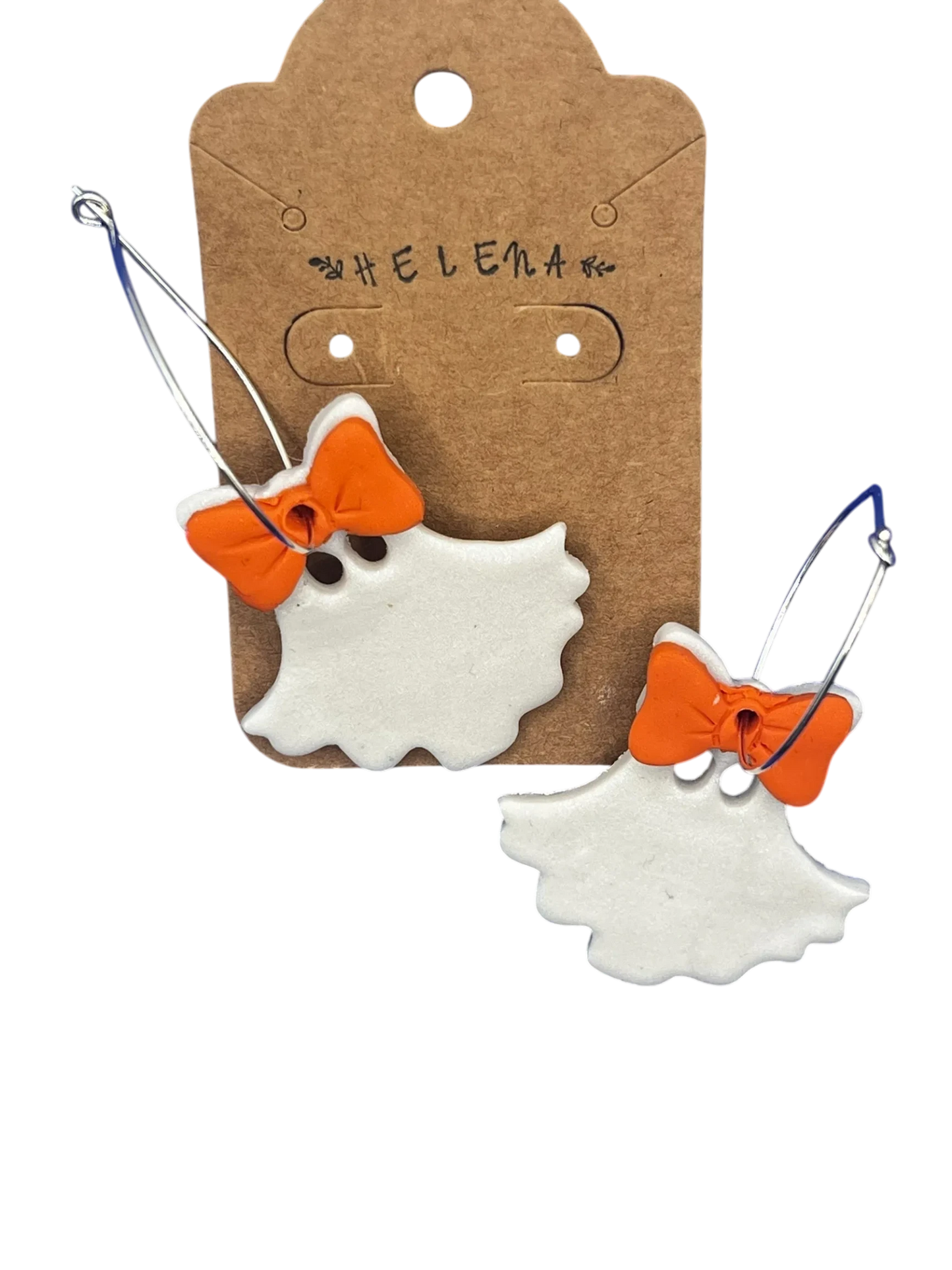 Helena’s Artisan & Gift Co. white ghost hoop earrings with orange bows on a branded cardboard display card.